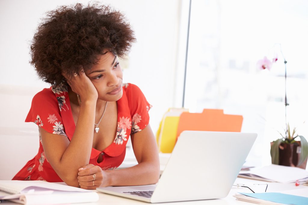 frustrated woman working at desk in design studio
