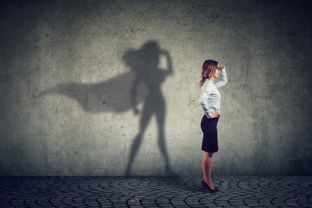 side view of a business woman imagining to be a super hero looki