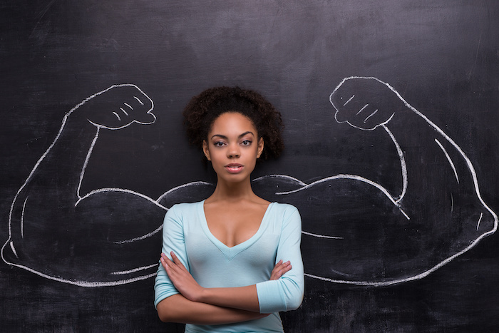 serious afro american woman with painted muscular arms on chalkboard